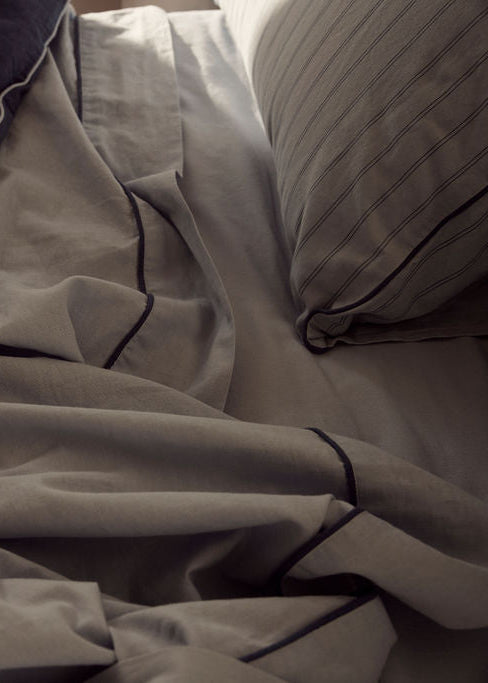 Close-up of rumpled bed sheets and pillow on a bed
